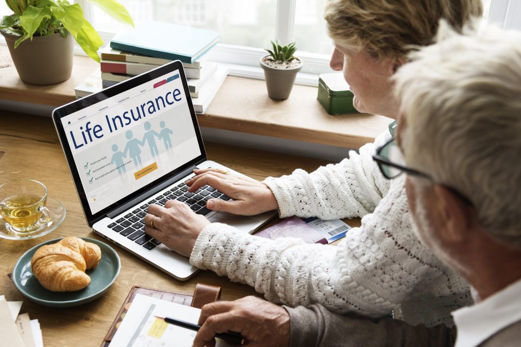 An older couple look at information about life insurance on their laptop