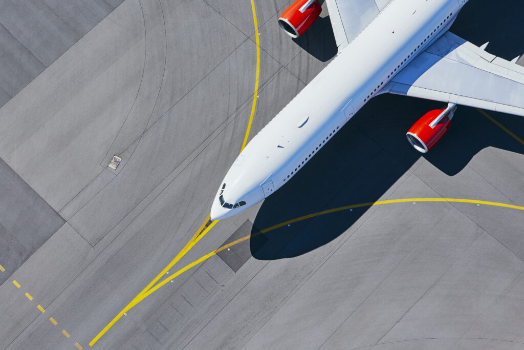 Aerial view of airplane with red jet engines.