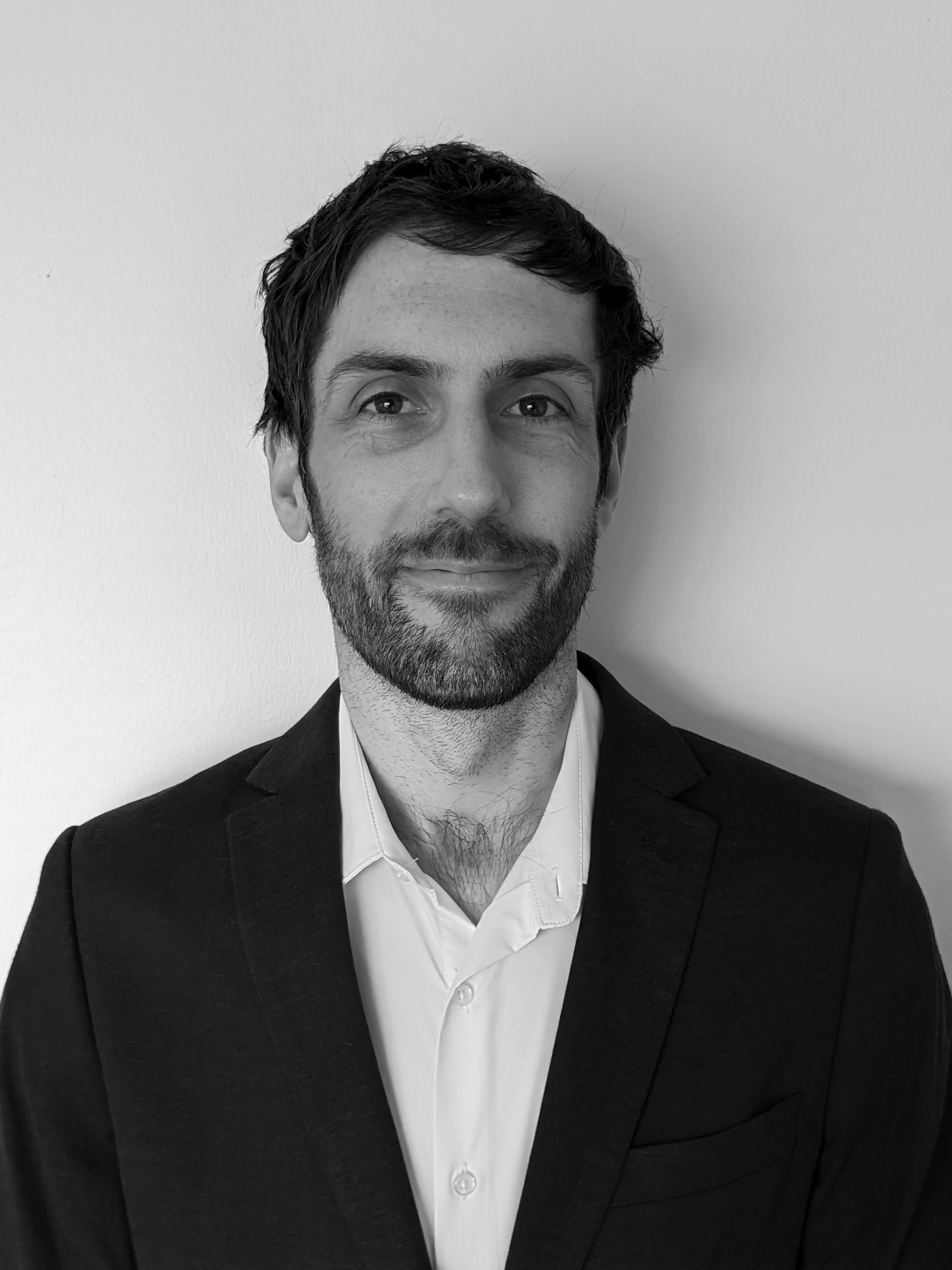 Headshot of Tom Wadsworth. He's wearing a suit jacket and collared shirt.