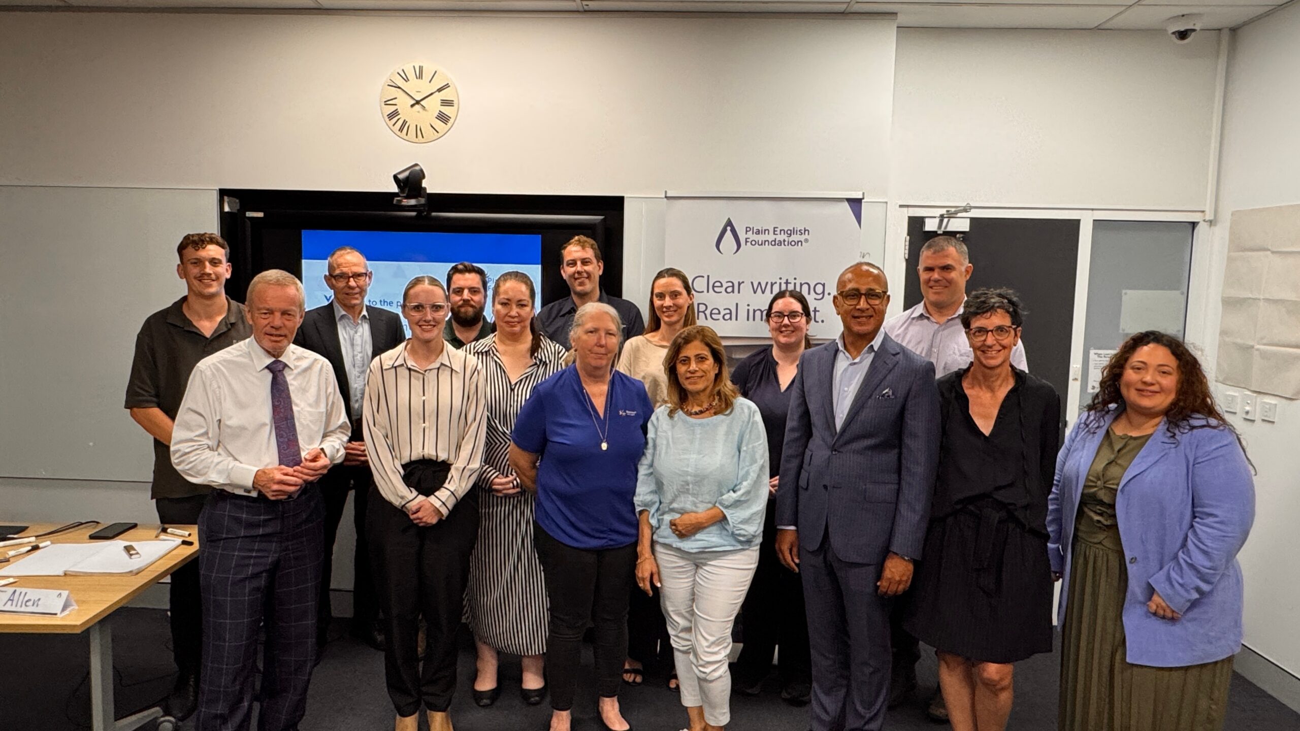 Plain English Foundation and Blacktown City Council representatives stand in a group in front of a Plain English Foundation banner.