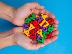 Different coloured plastic letters in person’s cupped hands